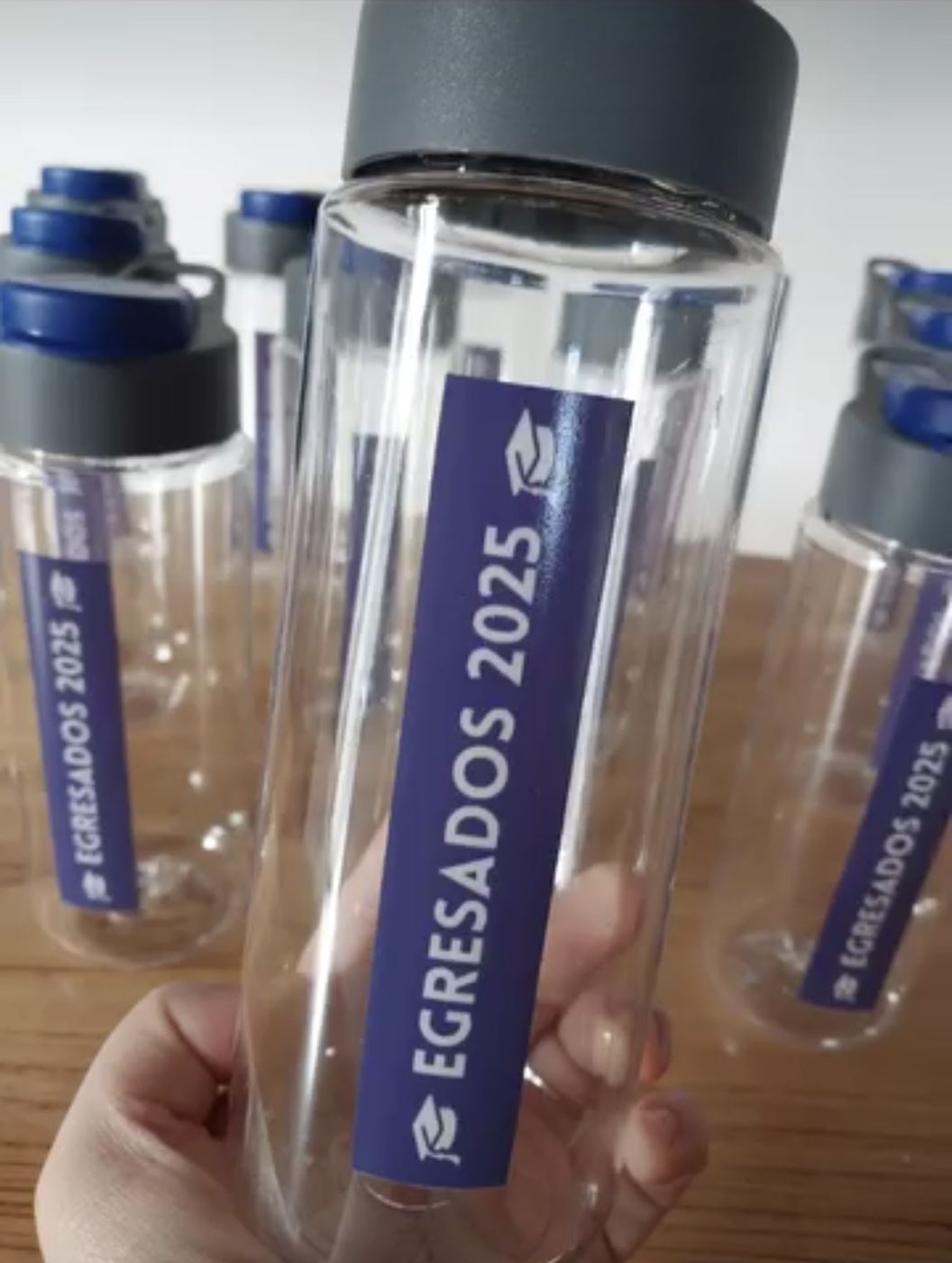 Botellas transparentes con etiqueta Egresados 2025
