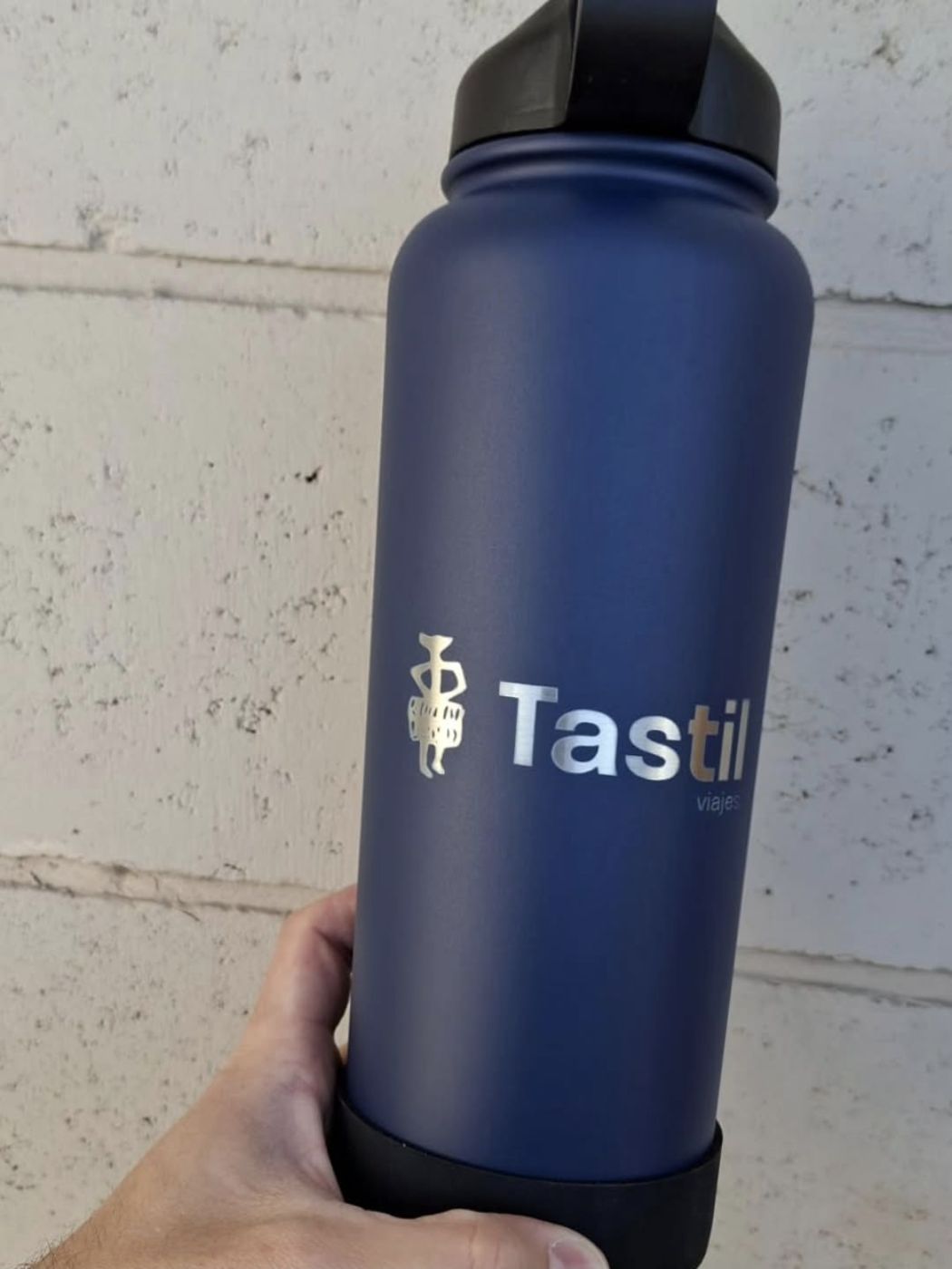 Botella azul grabada con logo de Tastil Viajes